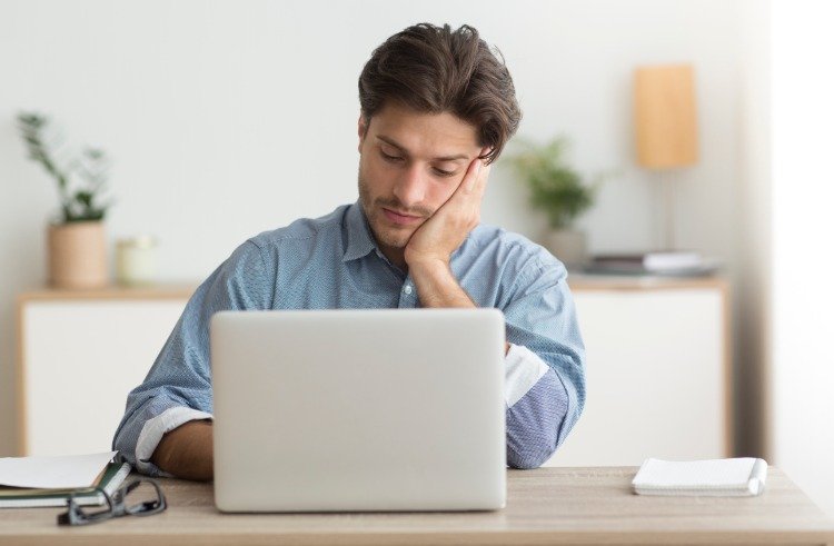 unavene vyzerajúci muž za počítačom pri práci