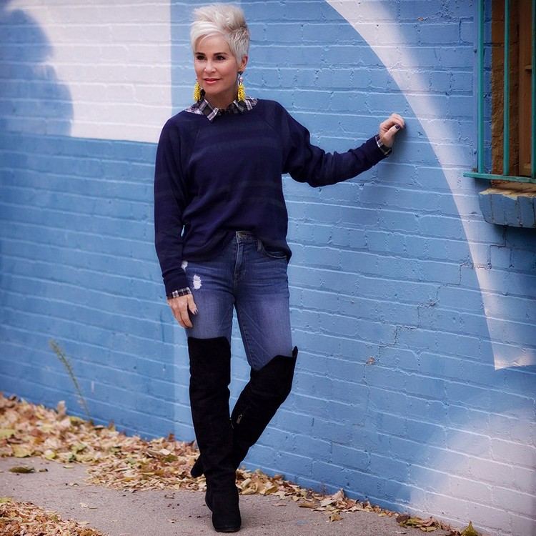 Módny outfit pre ženy nad 50 rokov kombinuje nad kolená čižmy s džínsami