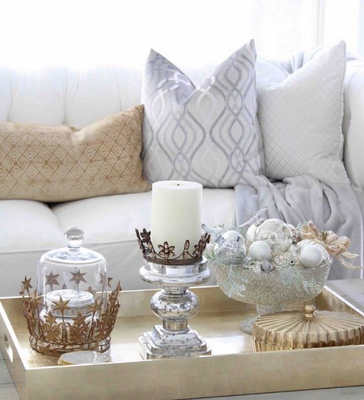 Vianočné ozdoby v striebornej miske a sviečky na gaučovom stole