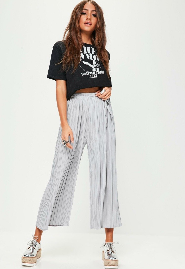 Plisované culottes kombinujú módne trendy tenisiek striebornej čiernej farby