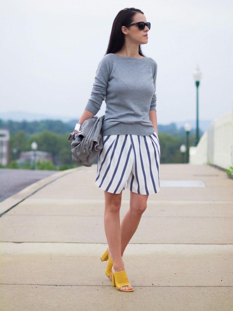 Žlté topánky so širokými bermudami a tenkým svetrom v šedej farbe