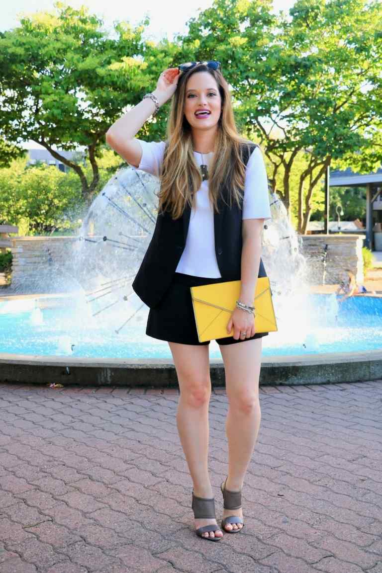 Idea s čiernymi šortkami a vestou a žltou kabelkou ako doplnok