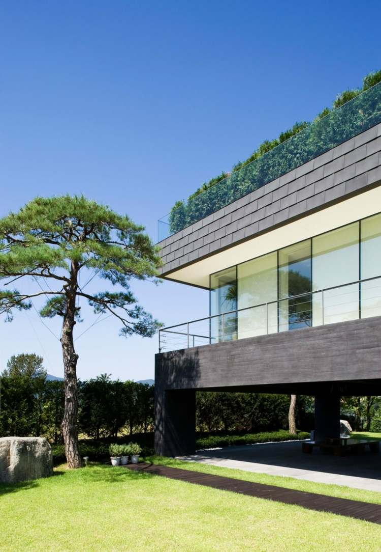 Balkónové zábradlie zo skleneného domu-skalný dvor-záhrada-črepníkové rastliny-chodník-strecha z dreva-terasa-balkón-stromy-výhľad