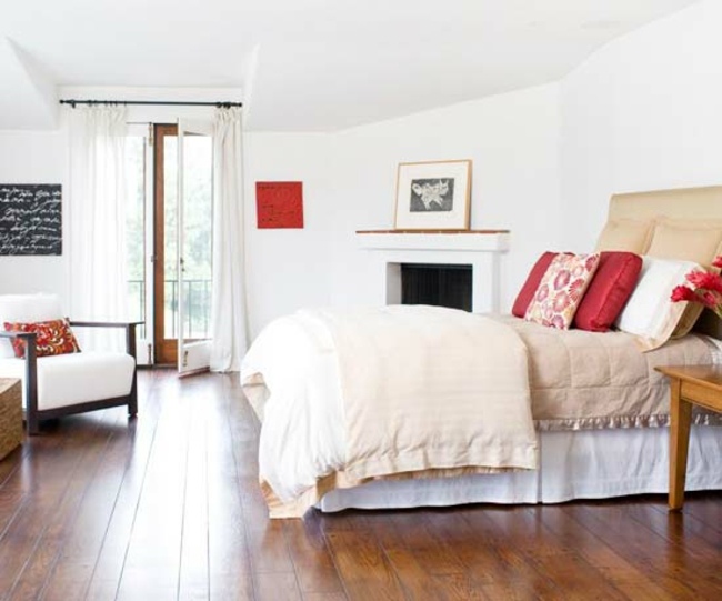 Spálňa biela farba červená dekorácia červený dekoračný vankúš drevená podlaha