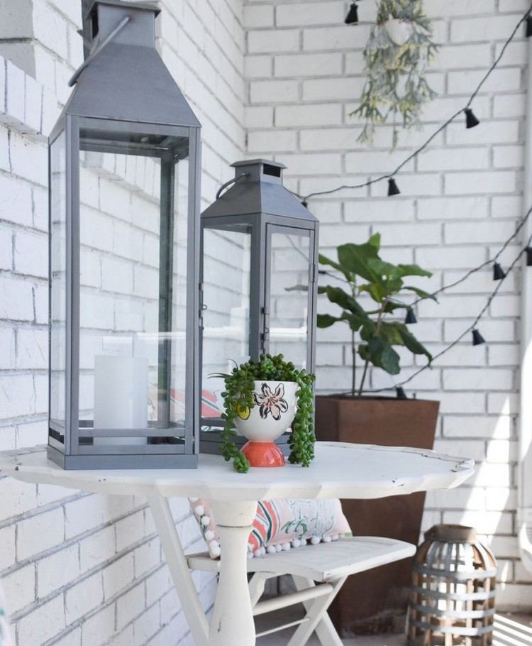 Malý stôl pri vchode do domu zdobený lampášmi