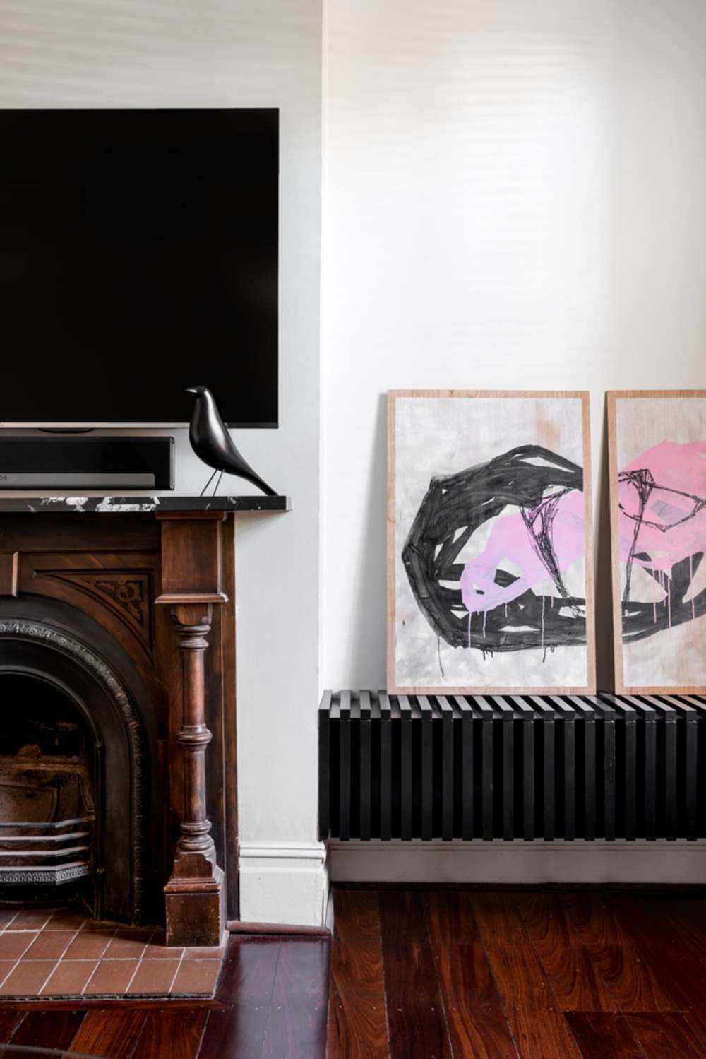 obývacia izba s TV nad krbom a obrazmi