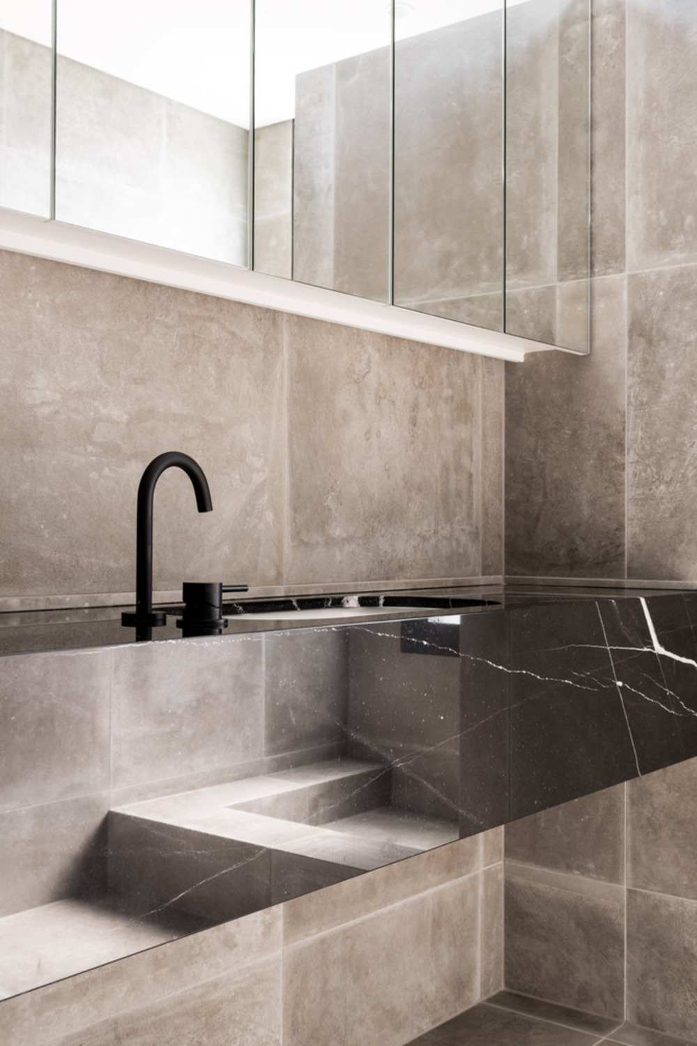 dlažba v kúpeľni v kombinácii s mramorovým umývadlom s čiernym faucetom