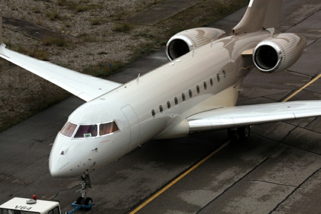 Súkromné lietadlo lietajúce na atraktívnych farebných pruhoch Súkromné prúdové lietanie s atraktívnymi farebnými pruhmi oranžovej farby