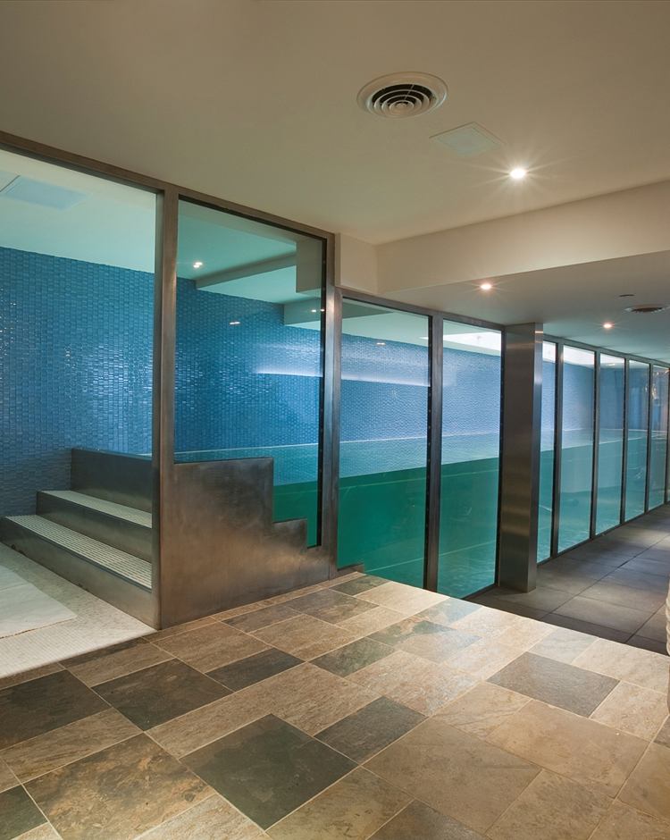 sklenená stena úzkeho bazéna v interiéri prirodzené svetlo