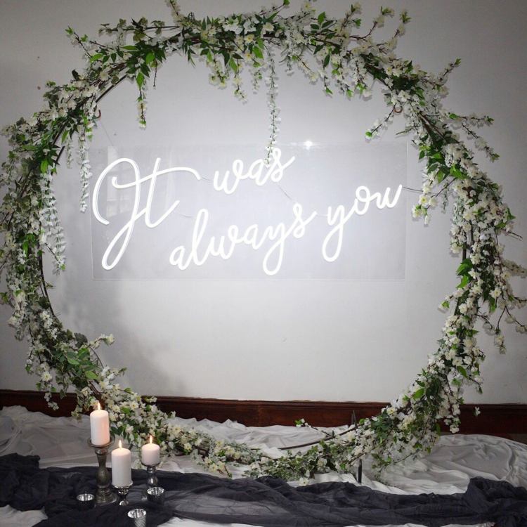 Veľký kvetinový veniec vo vintage štýle s visiacim neónovým skleneným nápisom