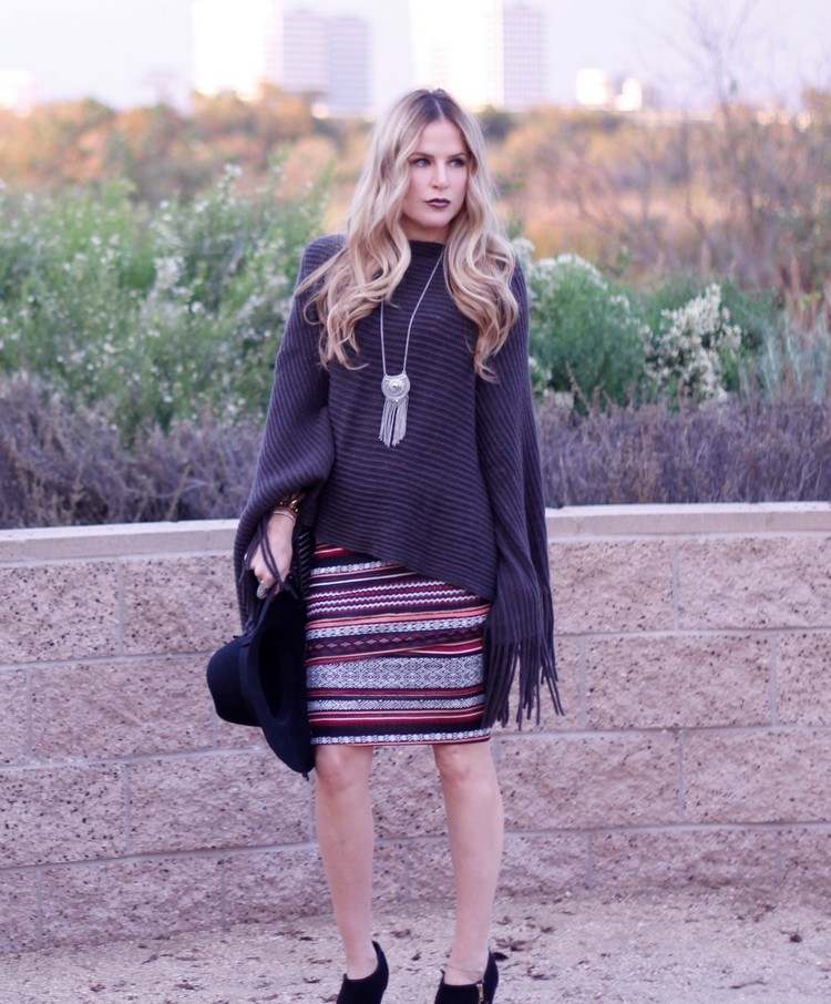 farebná vzorovaná sukňa, monochromatické pončo a dlhý náhrdelník módny trend neo bohémska čierno-monochromatická-pončo-retiazka-prívesok-vzorovaná-sukňa