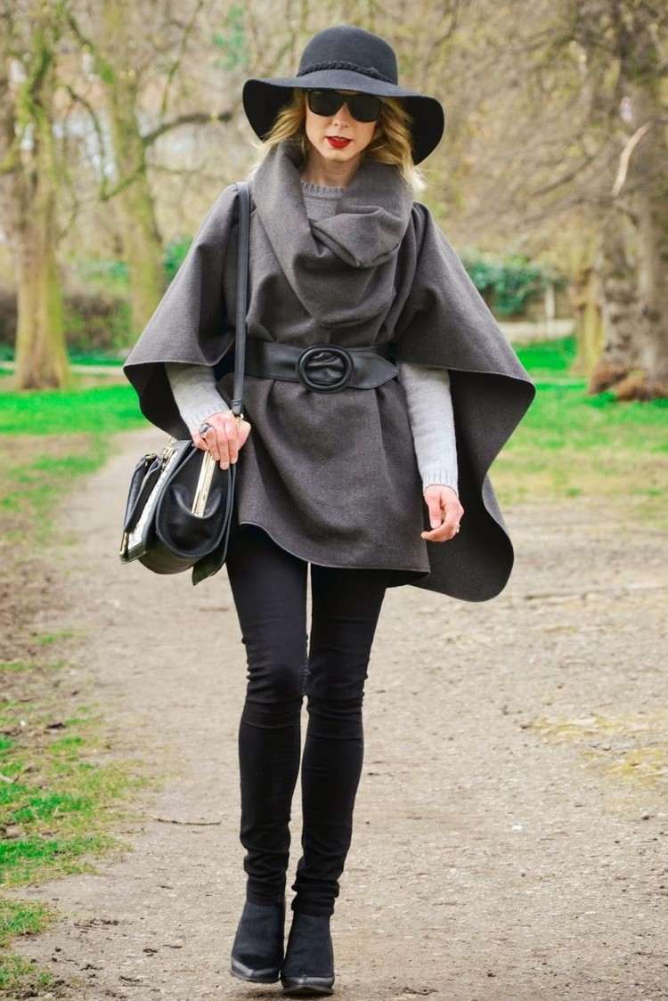 sivé pončo s koženým opaskom a klobúkom fedora módny trend-neo-bohémsky-sivá-pončo-kožený opasok-fedora-klobúk-čierne-nohavice-členkové čižmy
