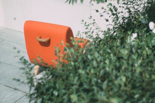 Rýchle kreslo v oranžovej farbe pri pohľade zozadu dizajnér-relax-kreslo-rapide-koliesko-tvar-pripomínať