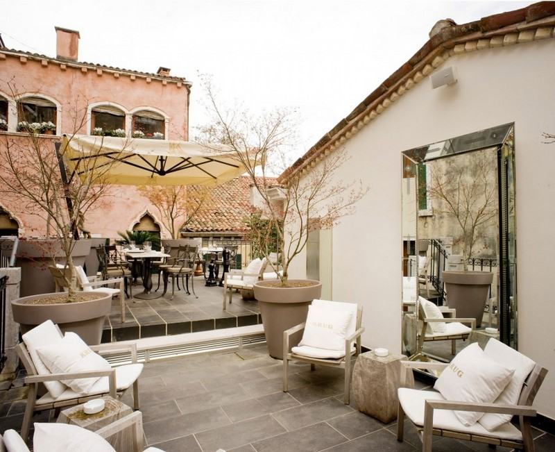 Terasa bola položená dlažobnými kockami a zariadená kovaným nábytkom Dizajnový nábytok - záhradný nábytok - drevo - jaseň - tepané železo