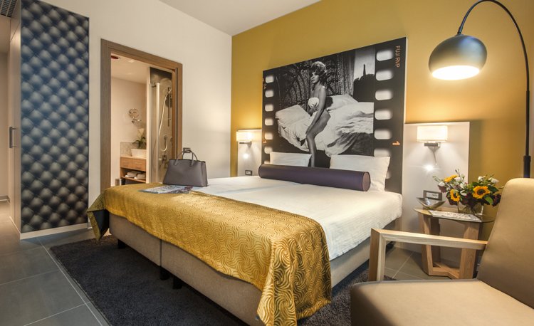 Prvotriedne koncepty izieb-okrová-žltá-akcentová stena-čierno-biela-fotografická posteľ-hlavná-šedá-dlažba