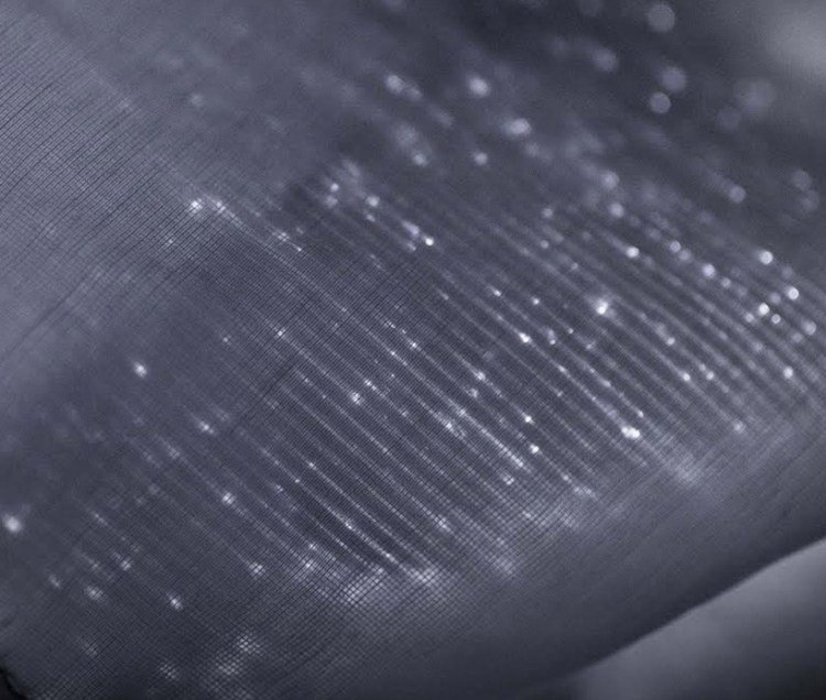 Vodiče zo sklenených vlákien sú vpletené do látky a lesknú sa tkanina zo sklolaminátu-športová bunda-nemen-tkaná