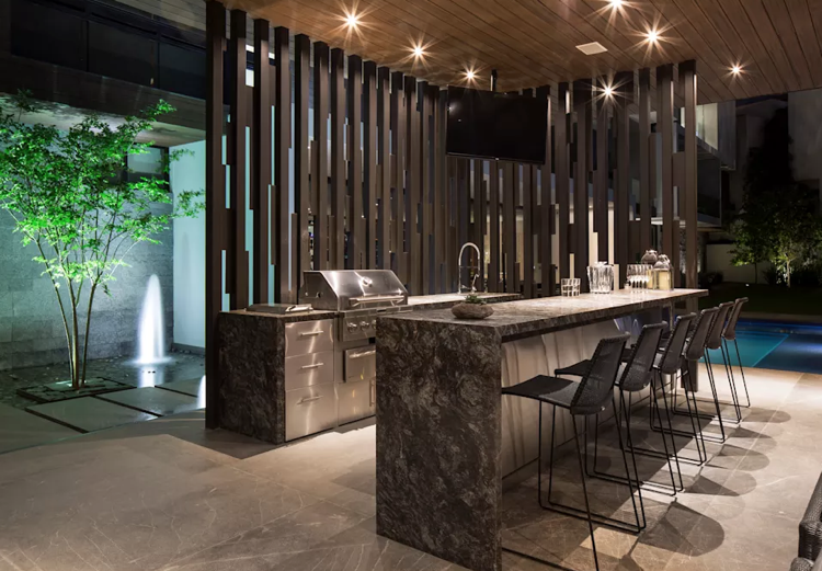 plynový gril letná kuchyňa nerezová pracovná doska sivá barové stoličky osvetlenie