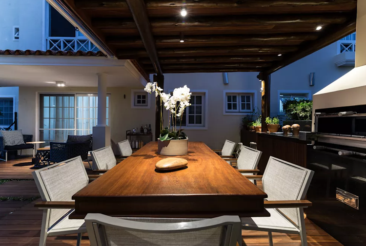 Jedáleň vonkajšia kuchyňa drevený jedálenský stôl hliníkové stoličky prútené