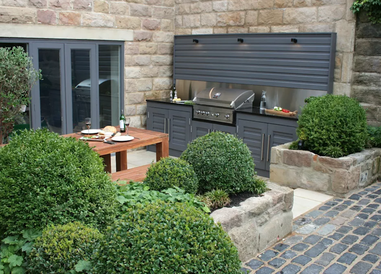 plynový gril letná kuchynská linka spodná skrinka šedá nerezová zadná stena jedálenský stôl drevo