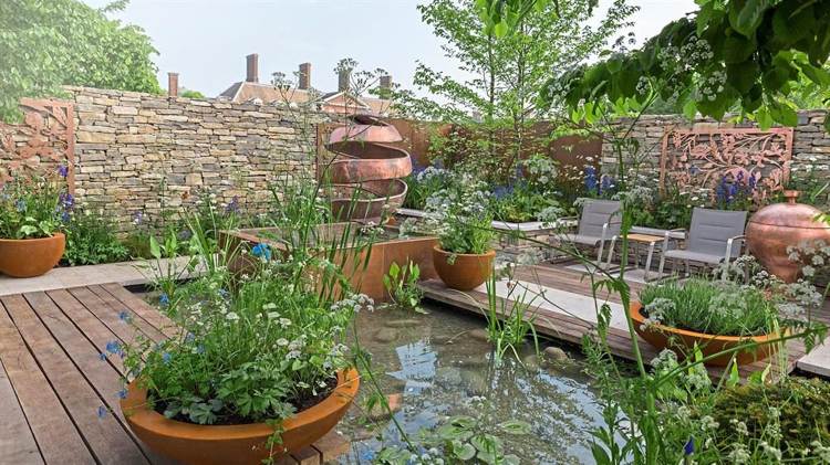 Vedro z ocele Corten okolo sochy rybníka so špirálou zo suchých kamenných múrov