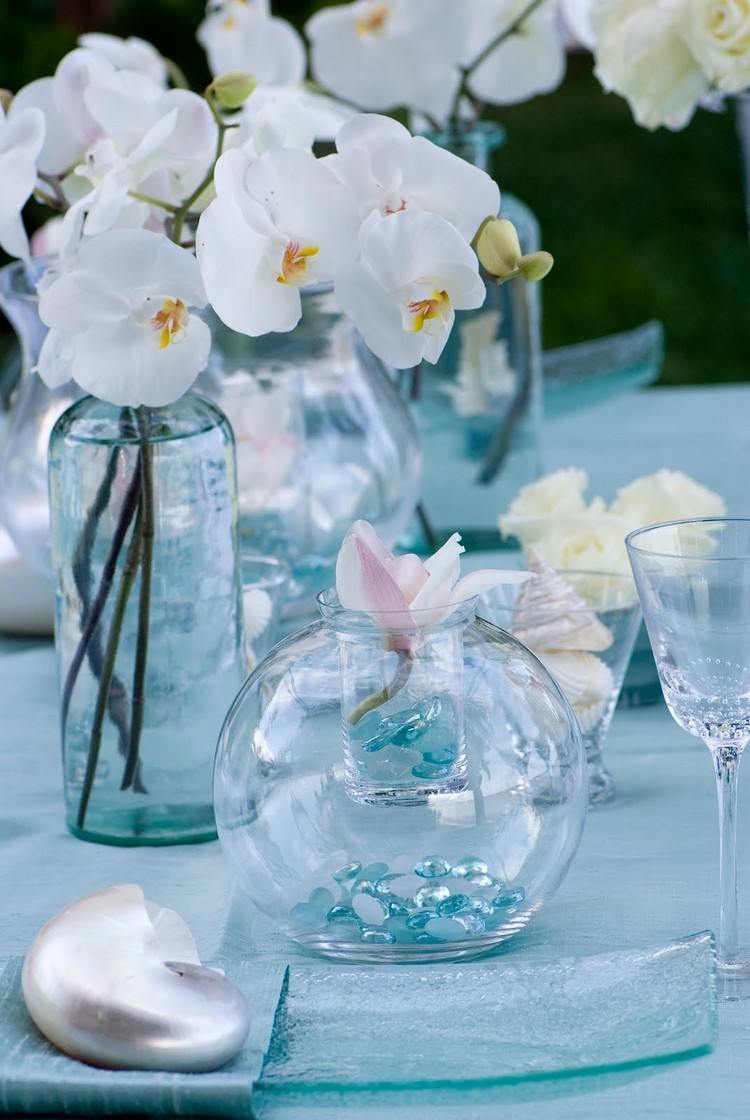 biele orchidey a modré sklenené kamienky plážový stôl-dekorácia-sklenená váza-modré-sklenené-kamienky-biele-orchidey