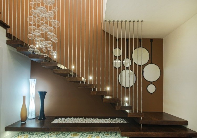 v prístupe točité schodisko tmavé drevo zvislé kovové tyče biely štrk