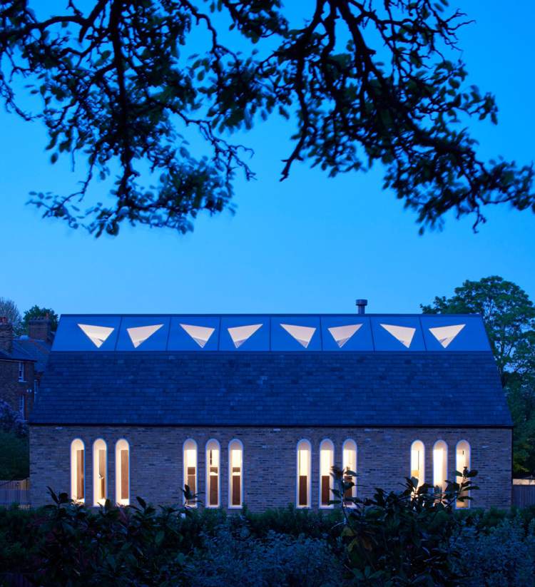 Prestavba sedlovej strechy na kaplnku s tehlovou fasádou s trojuholníkovými svetlíkmi