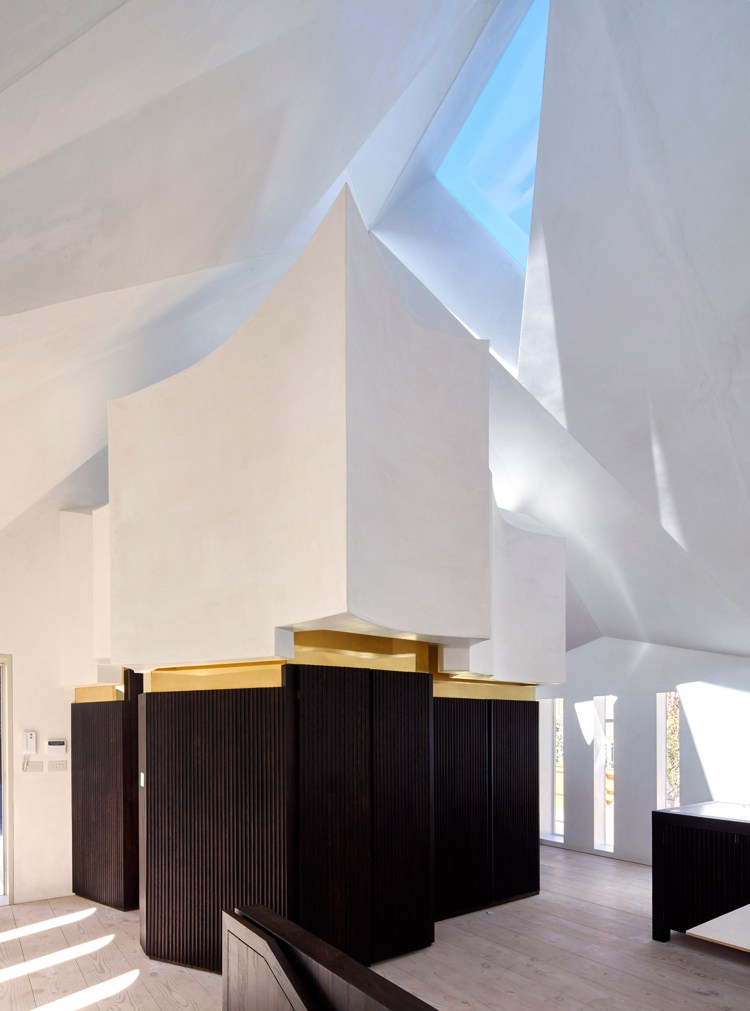 trojuholníkový svetlík zvýraznený tmavým drevom a mosadzou