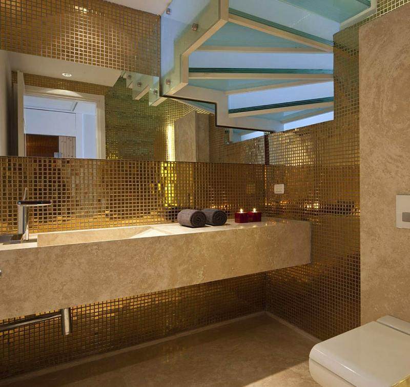 Zlaté mozaikové dlaždice na stene za pieskovcovým drezom Kúpeľňový dizajn zlaté obklady pieskovcové nástenné schody