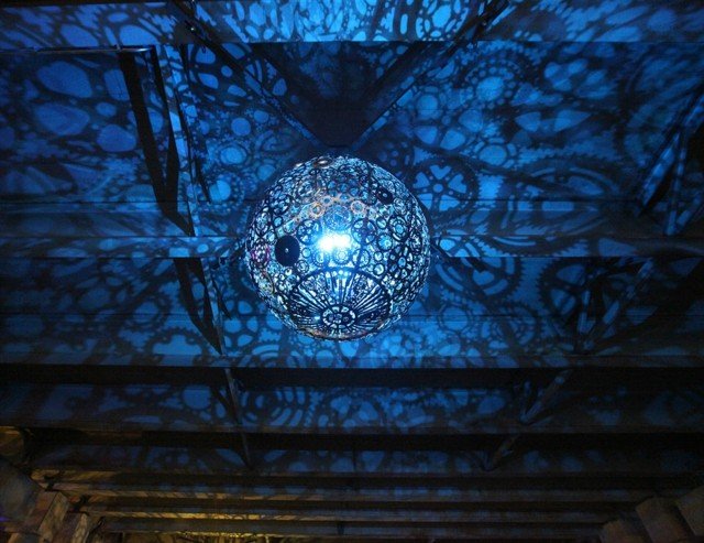 Závesné svietidlo vyrobené z velocipédových dielov s 3D efektom Kovové prvky-ako-guľa-s-modrým svetlom-ako-závesná lampa