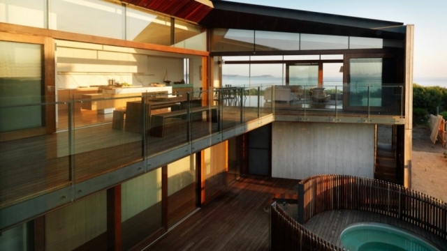 Dom so sklenenou fasádou, dom na pobreží, drevená paluba, vírivka