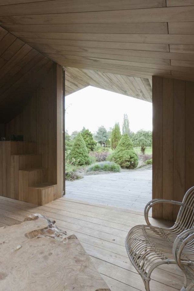 Záhradná chatka s drevenou strechou vchodové schody Ratanová stolička do domu s drevenou strechou