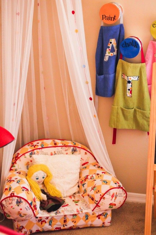 útulný rohový dizajn detskej izby s kreslom postele s baldachýnom