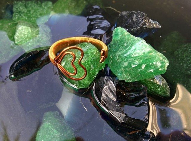 okolo neho je otvorený dvojitý krúžok z drôteného srdca