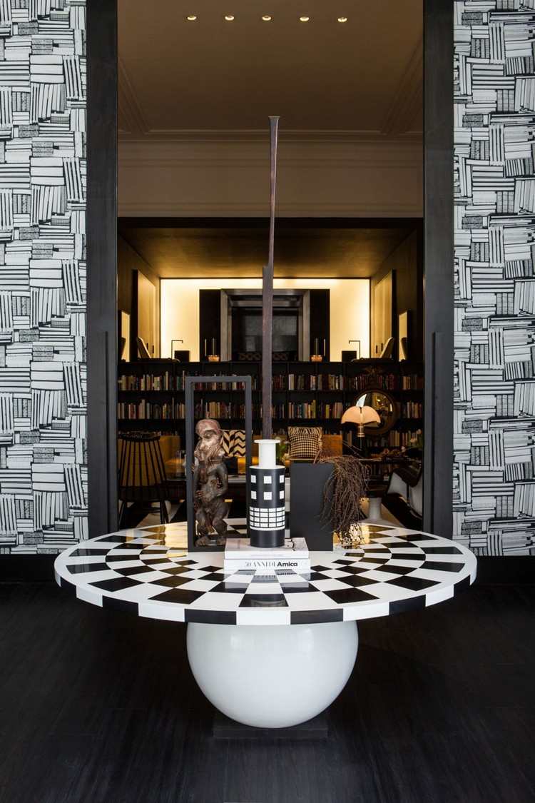 Zostava je v čiernobielom podstavci s guľatým stolom a vchodom