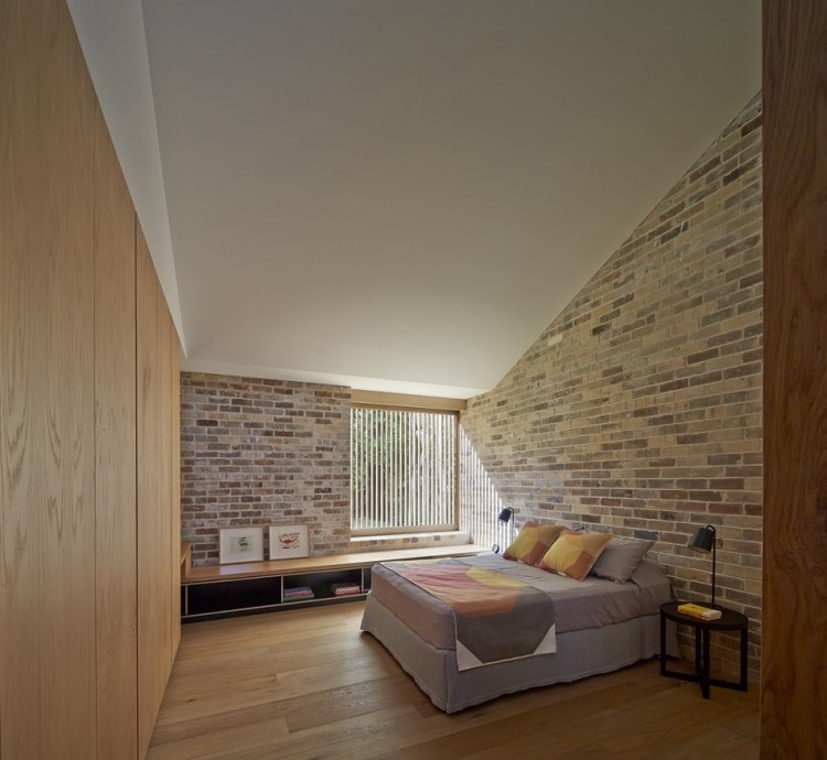 Spálňa s neošetrenou tehlovou stenou a šatníkom Nápady na nábytok-vstavaný šatník vo vidieckom štýle