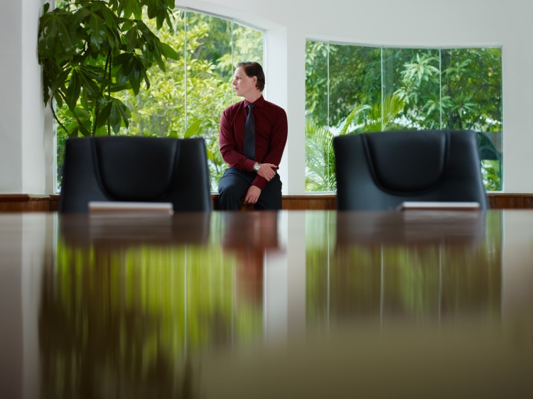 podnikateľ sa pozerá z okna v rokovacej miestnosti