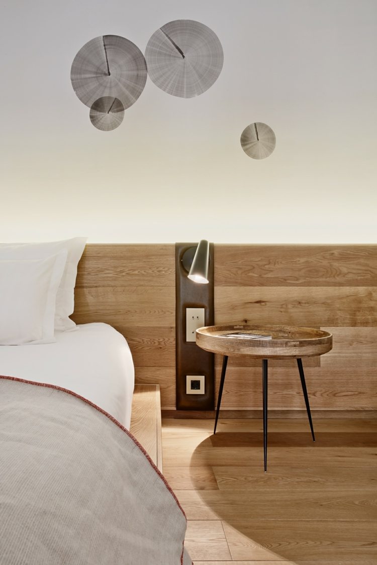 Spálňa s drevenou podlahou a zaujímavými ozdobami na stenu Konopné lano-zábradlie-spálňa-bočný stôl-stena-ozdoby-posteľná bielizeň-drevo-parkety-podlaha-svetlý-zásuvkový spínač