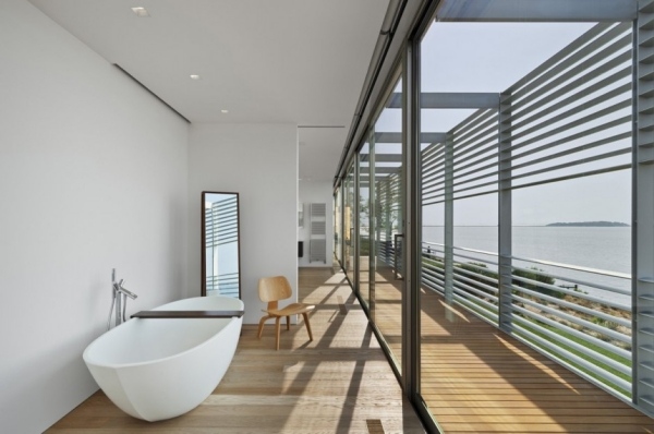 Kúpeľňa s vaňou s výhľadom na more a drevenou podlahou