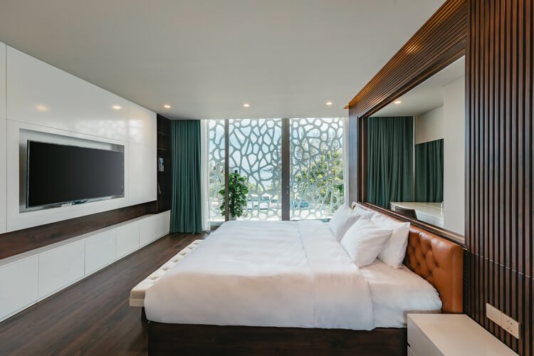 Spálňa so vstavanou šatníkovou skriňou a manželskou posteľou s koženým čelom postele