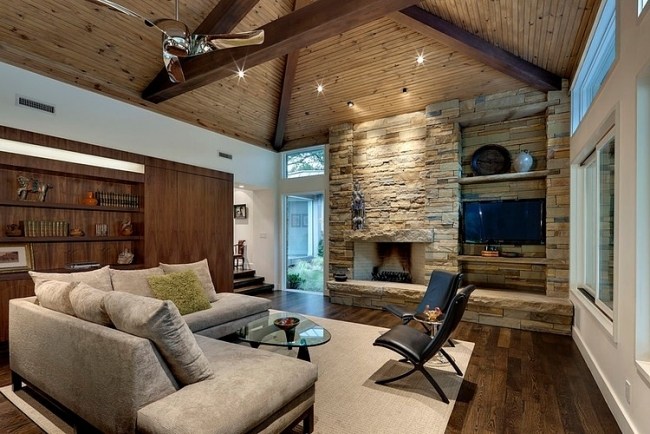 Interiérová rezidencia Drevený trámový sedací gauč so sivým čalúneným krbom zapustené stropné svetlá