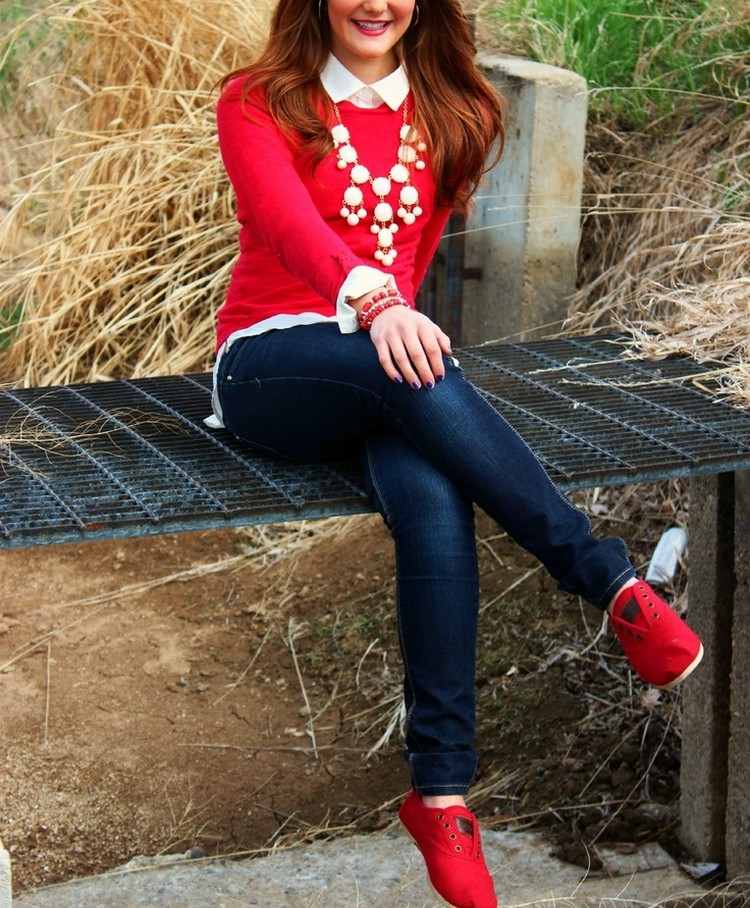 biela košeľa pod červeným svetrom a modrými džínsami farba-červeno-trendový-outfit-biela-košeľa-červený-sveter-rifle-červené-topánky
