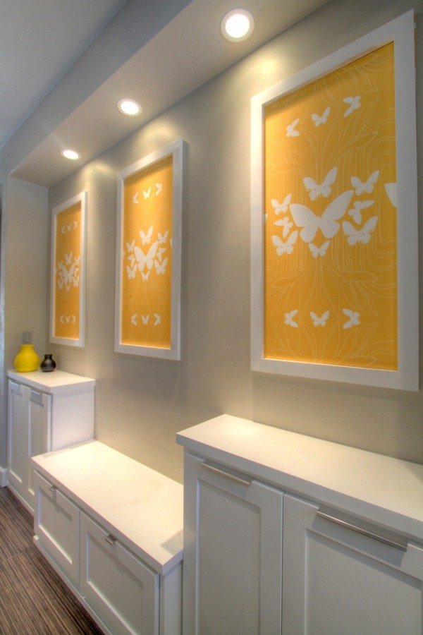 Dekor chodby s identickými obrázkami-bielo-žlto-umelecky osvetlené Farebný dizajn-na chodbe-príjemné-obývacia-atmosféra-dekoratívne-svetlo