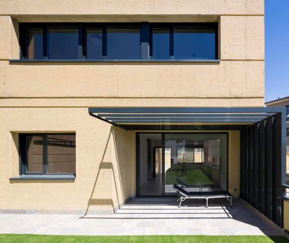 Vchod z moderného domu so strechou a ležadlom