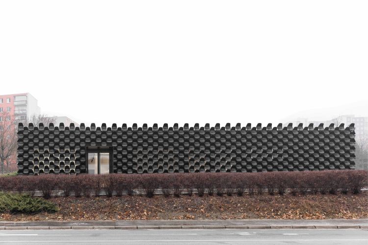 dom z recyklovaného materiálu fasádna konštrukcia moderný udržateľný dizajn konštrukcia recyklácia opätovne použitých plastových stoličiek