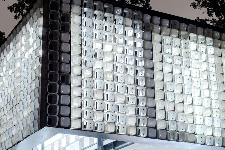 dom z recyklovaného materiálu fasádna konštrukcia moderný udržateľný dizajn konštrukcia recyklácia opätovné použitie mikro knižnice poháre