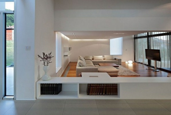 moderný interiér obývačky obývacia izba sedacia súprava béžová Interiér béžový kožený nábytok pohovka knihy police biele steny