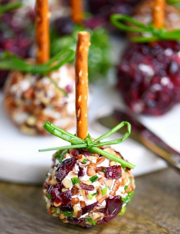 Krémové tvarohové gule ako vianočné jedlo na prst ozdobia stužkou z pažítky