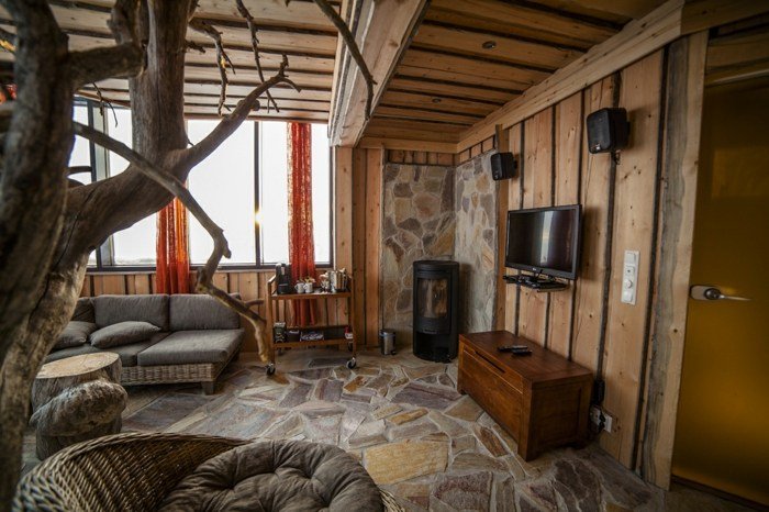 Po safari sa môžete zahriať pri krbe sedacia súprava do obývačky s kamenným nábytkom a rustikálnym krbom