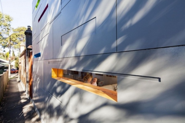 Moderný dom s geometrickým pôdorysom-sivá fasáda, úzke okenné otvory